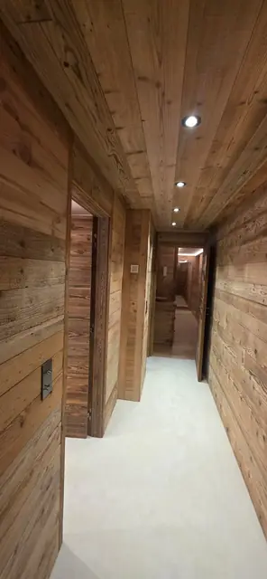 Couloir de chalet avec spots LED encastrés dans le plafond en bois