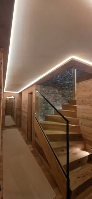 Escalier de chalet avec éclairage LED indirect au plafond