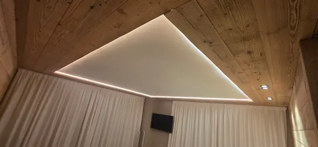 Faux plafond à éclairage LED indirect dans une chambre de chalet