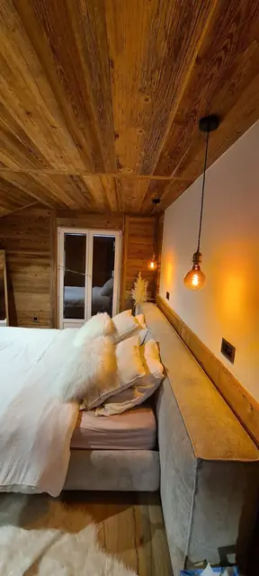 Suspension à ampoule filament au chevet d'un lit en chalet bois