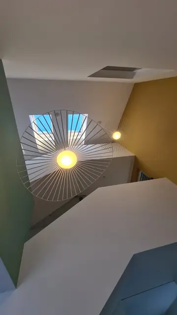 Suspension design sous un puits de lumière dans une cage d'escalier